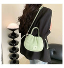 Bolsa bucket texturizada verde-claro com alças brancas, pendurada ao ombro