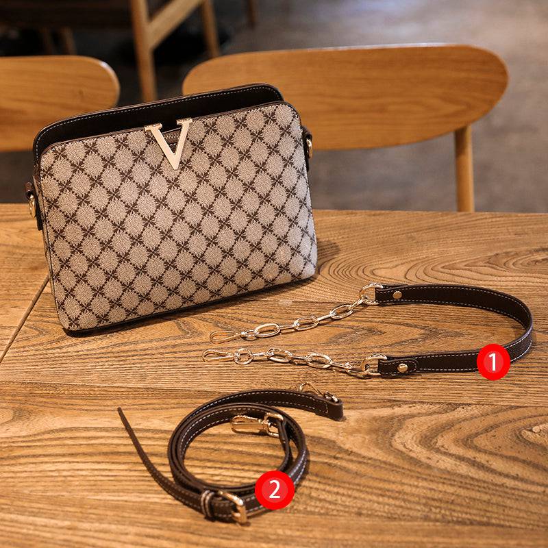 Bolsa Feminina de Couro Elite bege, estampa de monograma, logo "V" dourado. Alça transversal ajustável com detalhes em couro e corrente metálica. Sofisticada e versátil.