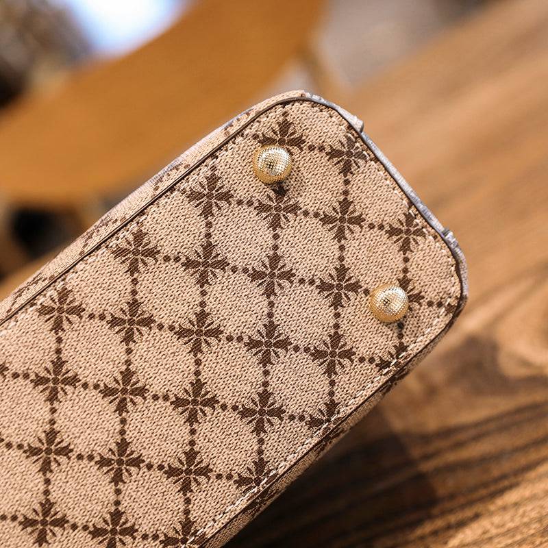 Bolsa Feminina de Couro Elite bege. Detalhe da base com estampa de monograma e pés de metal dourados. Acabamento de alta qualidade.