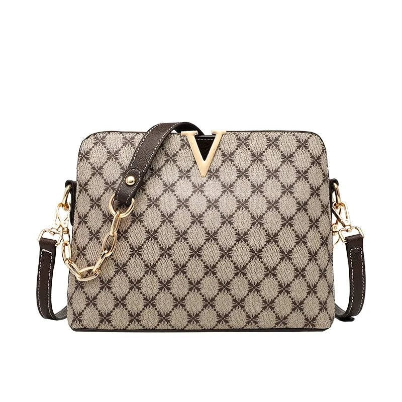 Bolsa Feminina de Couro Elite bege, estampa de monograma, logo "V" dourado. Alça de corrente e detalhes em couro marrom. Sofisticada e elegante.