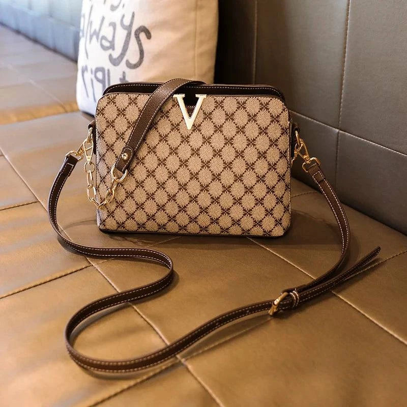 Bolsa Feminina de Couro Elite bege, estampa de monograma, logo "V" dourado. Alça de corrente e transversal ajustável. Elegante e versátil.