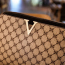 Bolsa feminina bege com estampa acolchoada e logo "V" dourado