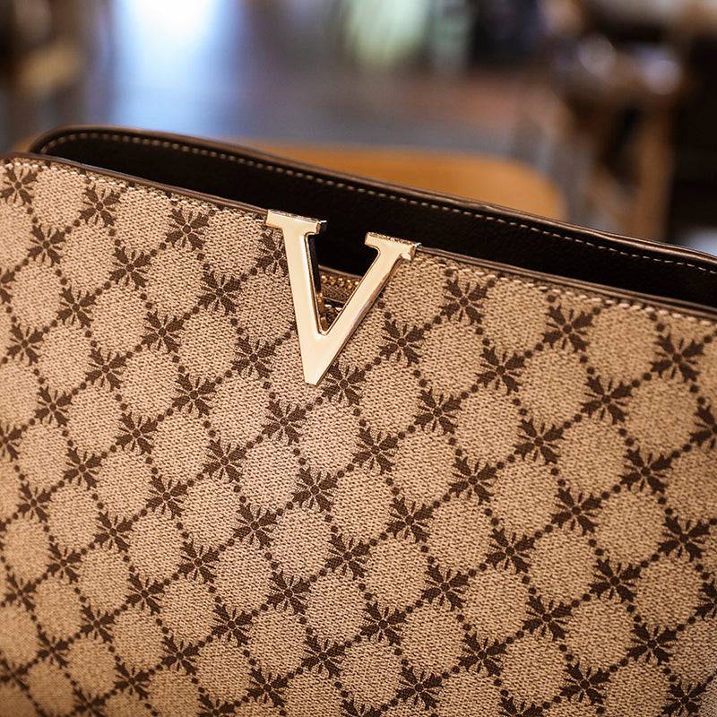 Bolsa Feminina de Couro Elite bege. Detalhe da estampa de monograma e logo "V" dourado em metal. Design sofisticado e exclusivo.