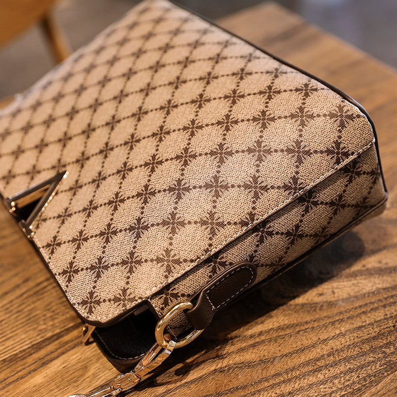 Bolsa Feminina de Couro Elite bege. Detalhe da estampa de monograma e textura do couro. Vista superior, com logo "V" dourado. Sofisticada e elegante.