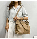 Mulher com bolsa feminina de couro bege em estilo tote com alça de ombro