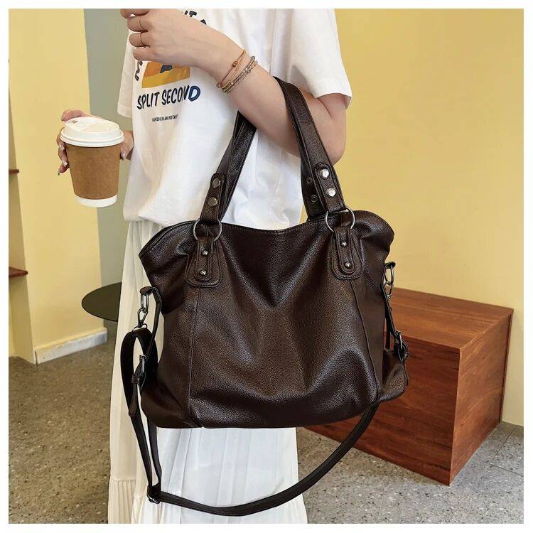 Bolsa Feminina de Couro Horizon marrom-escuro. Design espaçoso e maleável, com textura de couro e ferragens prateadas. Ideal para looks casuais.