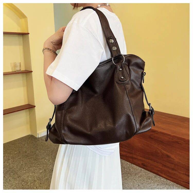 Bolsa Feminina de Couro Horizon marrom-escuro. Design espaçoso e maleável, com textura de couro e ferragens prateadas. Elegante e versátil.