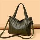 Bolsa feminina de couro verde-escuro com frisos verticais e alças trançadas