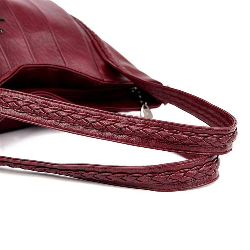 Bolsa Feminina Couro Horizon One vinho. Detalhe da alça trançada em couro, adicionando um toque de sofisticação ao design da bolsa.