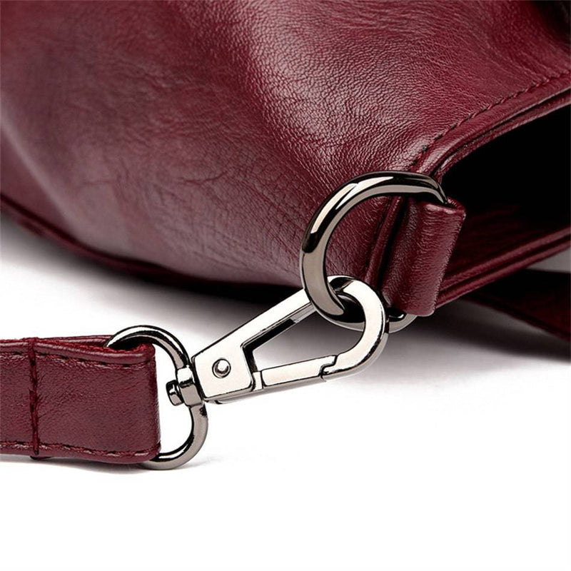 Bolsa Feminina Couro Horizon One vinho. Detalhe da ferragem metálica escura que conecta a alça, evidenciando a qualidade e durabilidade.