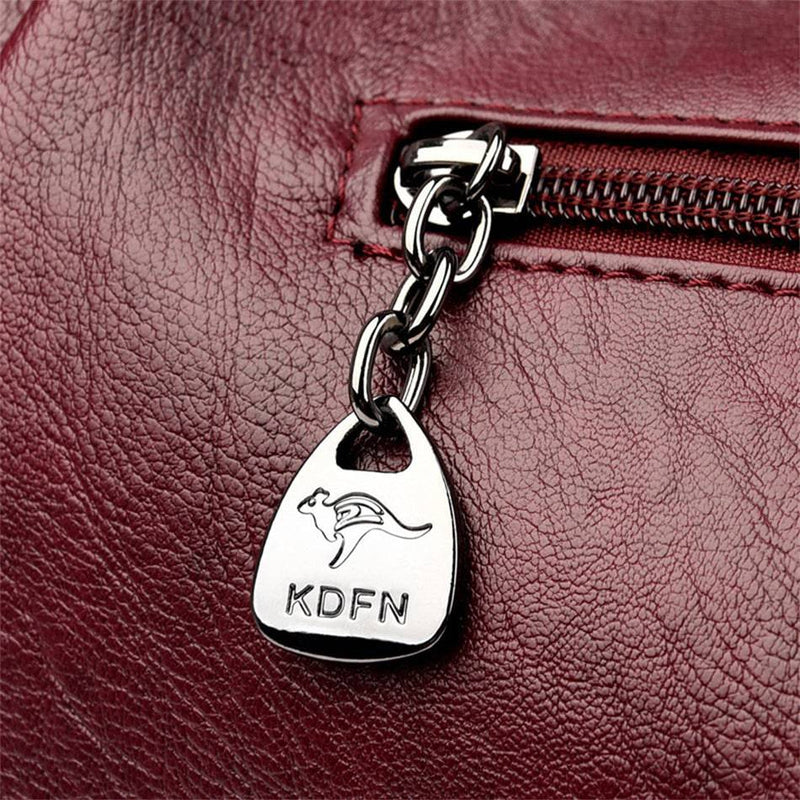 Bolsa Feminina Couro Horizon One vinho. Detalhe do puxador de zíper metálico com logo de canguru. Acabamento refinado e exclusivo.