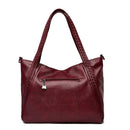 Bolsa feminina de couro vinho com alças trançadas e bolso frontal com zíper