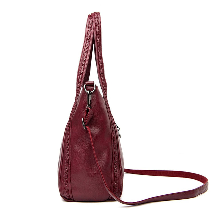 Bolsa Feminina Couro Horizon One vinho. Vista lateral com couro macio, alças trançadas e alça transversal. Design espaçoso e elegante.