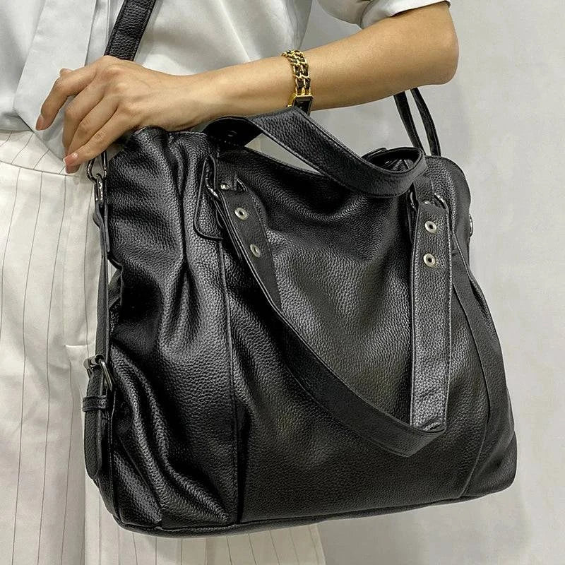 Bolsa Feminina de Couro Horizon preta. Design espaçoso e maleável, com textura de couro e ferragens prateadas. Prática e moderna.
