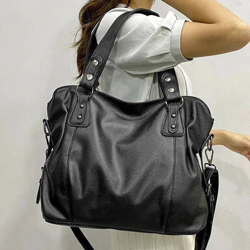 Bolsa Feminina de Couro Horizon preta, com textura sutil e design maleável. Possui alças de ombro e transversal, ferragens prateadas. Elegante e versátil.
