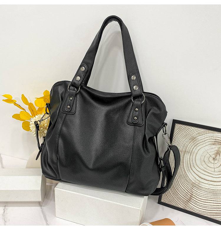 Bolsa Feminina de Couro Horizon preta. Design espaçoso e maleável, com textura de couro e ferragens prateadas. Prática e moderna.