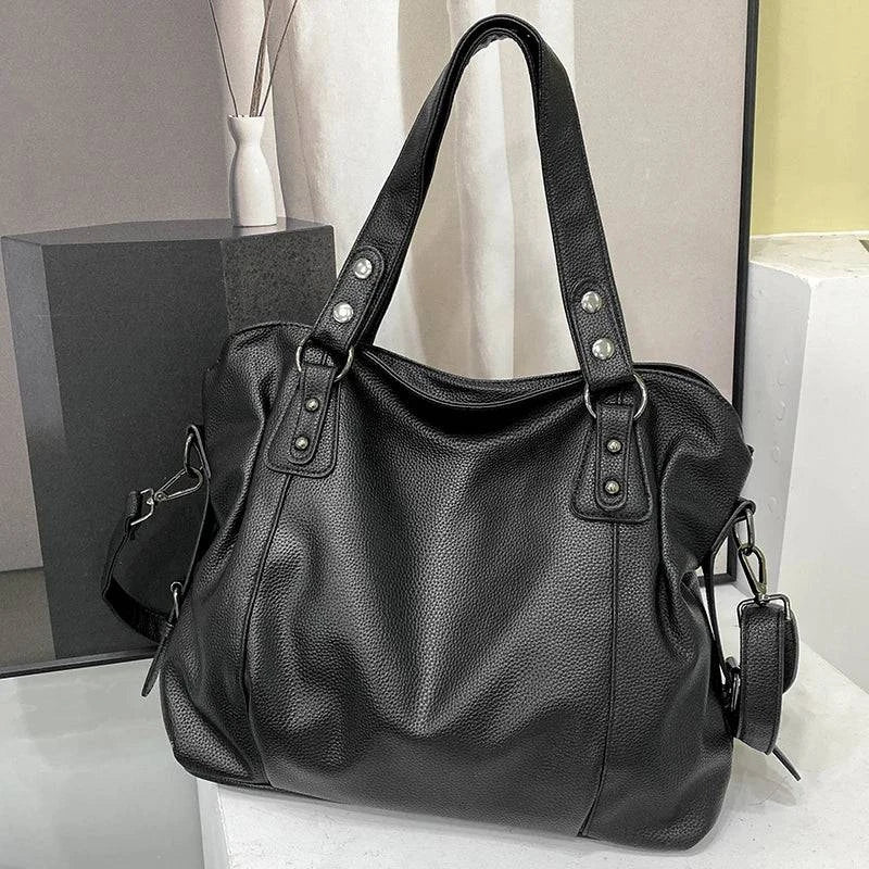 Bolsa Feminina de Couro Horizon preta. Design espaçoso e maleável, com textura de couro e ferragens prateadas. Prática e moderna.