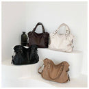 Quatro bolsas femininas em preto, branco, marrom e caramelo com alças duplas e ferragens metálicas
