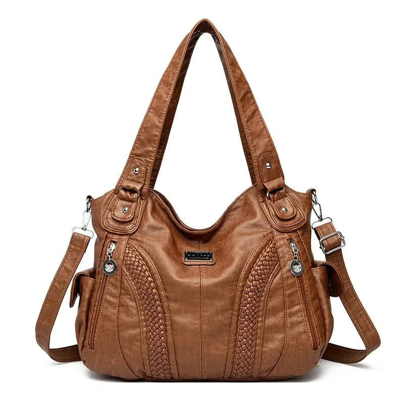 Bolsa feminina de couro legítimo Charmonia na cor caramelo, com alça de ombro, detalhes trançados na parte frontal, bolso lateral com zíper e ferragens prateadas.