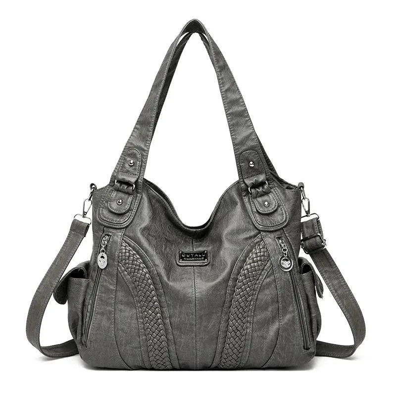Bolsa feminina de couro legítimo Charmonia na cor cinza, com alças de ombro largas, detalhes trançados na frente, bolsos laterais e zíper prateado.