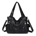 Bolsa feminina de couro legítimo preta Charmonia com alça de ombro, detalhes trançados na frente, bolso com zíper lateral e ferragens prateadas, ideal para looks modernos e sofisticados.