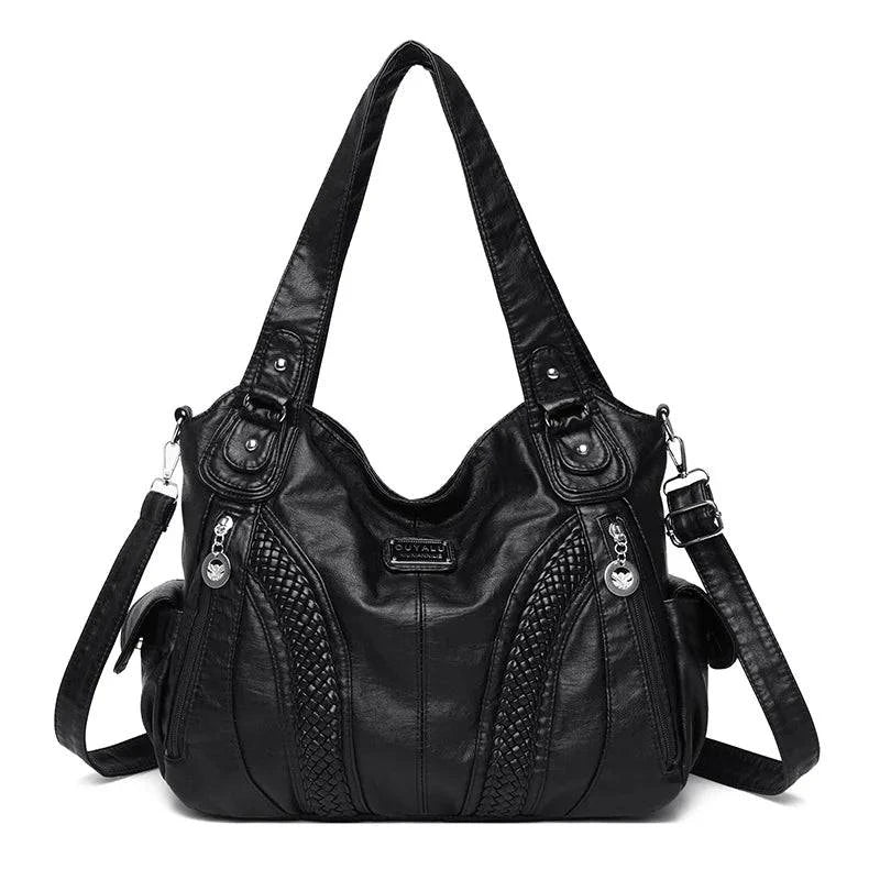 Bolsa feminina de couro legítimo preta Charmonia com alça de ombro, detalhes trançados na frente, bolso com zíper lateral e ferragens prateadas, ideal para looks modernos e sofisticados.