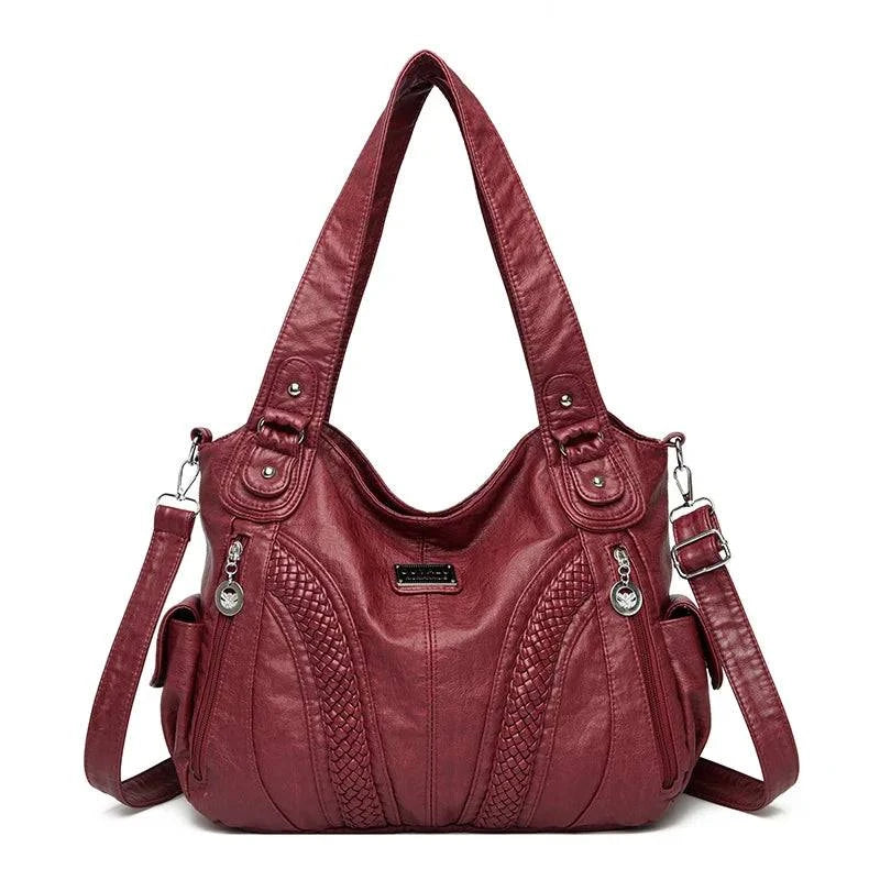 Bolsa feminina de couro legítimo Charmonia na cor vinho, com alças de ombro largas, detalhes trançados na frente, bolsos laterais e ferragens prateadas.