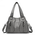 Bolsa Feminina Couro Legítimo Luxe Essence cinza, com bolsos frontais e ferragens prateadas. Alças duplas e transversal. Elegante e funcional.