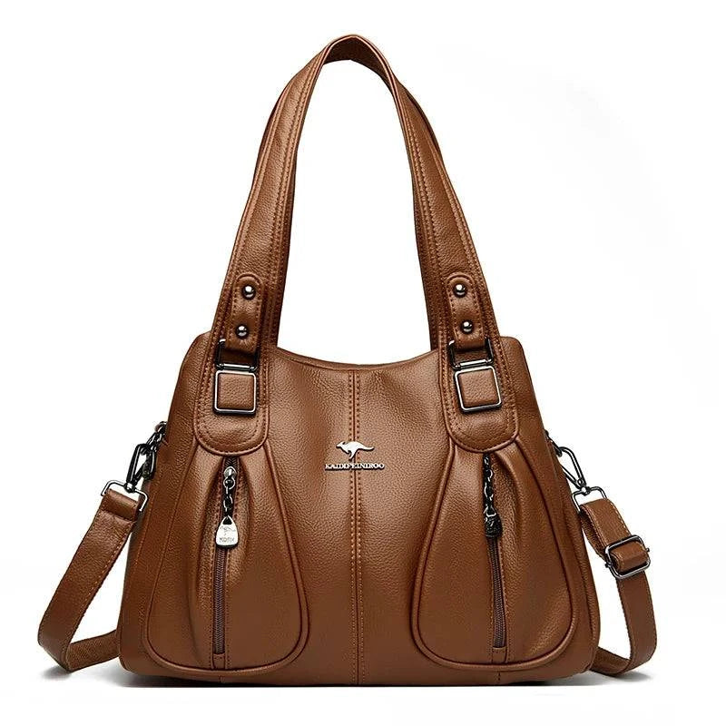 Bolsa Feminina Couro Legítimo Luxe Essence marrom, com bolsos frontais e ferragens prateadas. Alças duplas e transversal. Elegante e funcional.
