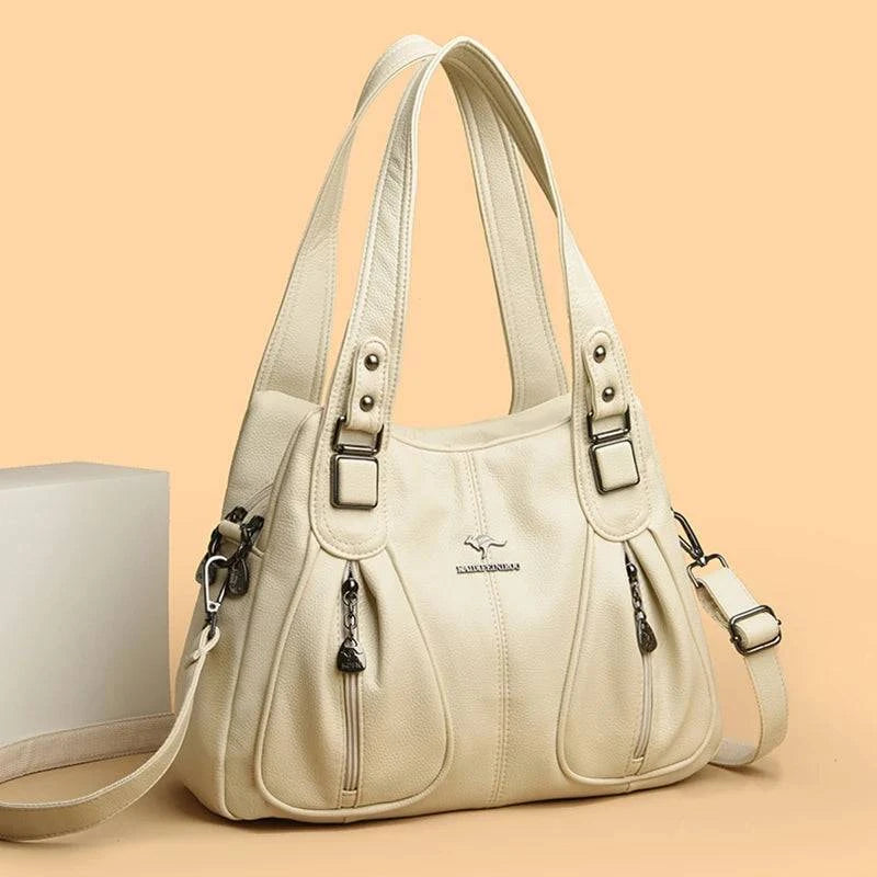 Bolsa Feminina Couro Legítimo Luxe Essence off-white, com bolsos frontais e ferragens prateadas. Alças duplas e transversal. Elegante e funcional.