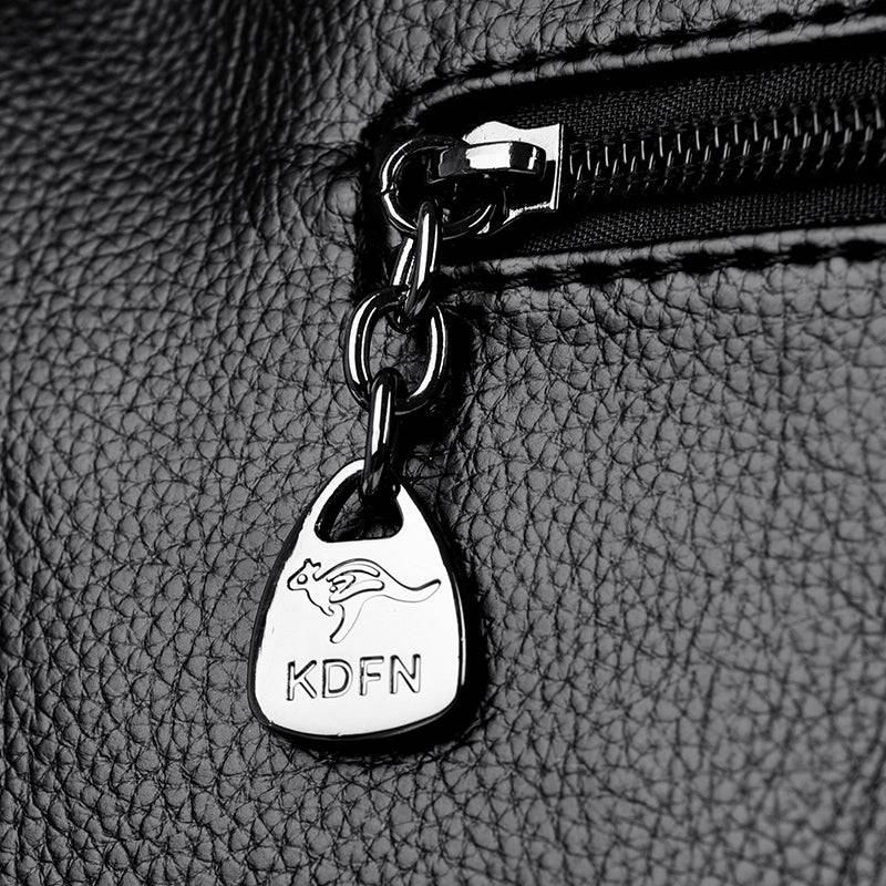 Bolsa Feminina Couro Legítimo Luxe Essence preta. Detalhe do puxador de zíper metálico com logo de canguru. Acabamento refinado e exclusivo.
