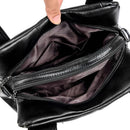 Bolsa de couro preta aberta mostrando interior com compartimentos e zíper