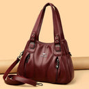 Bolsa de couro burgundy com alças duplas, bolsos frontais e alça transversal ajustável