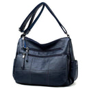 Bolsa feminina azul marinho com múltiplos bolsos com zíper e detalhes acolchoados