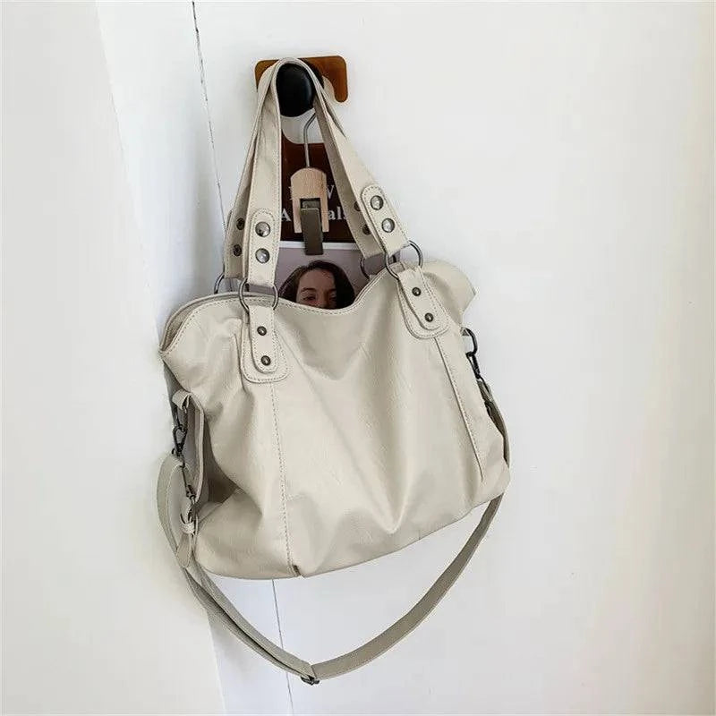 Bolsa Feminina Couro Sintético Casual Tote bege, design maleável e espaçoso. Ideal para o dia a dia e versátil.