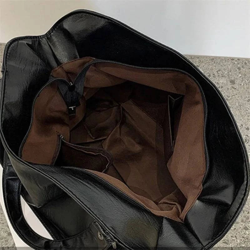 Bolsa Feminina Couro Sintético Casual Tote preta. Interior espaçoso com bolsos e zíper. Praticidade para organizar.