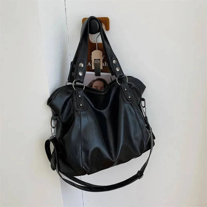 Bolsa Feminina Couro Sintético Casual Tote preta, design maleável e espaçoso. Ideal para o dia a dia e versátil.