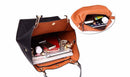 Bolsa tote de couro marrom com interior laranja, aberta mostrando compartimentos com produtos