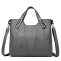 Bolsa Feminina Estruturada Transversal cinza-chumbo, couro sintético texturizado. Alças de mão com ferragens metálicas e alça removível. Elegante e versátil.