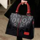 Bolsa de couro preta com estampa de letras em relevo, alças vermelhas e zíper vermelho central