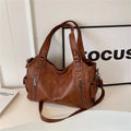 Bolsa feminina hobo em couro marrom com alças reforçadas, bolsos laterais e detalhes de zíper frontal metálico