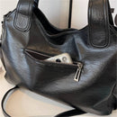 Bolsa hobo preta de couro com smartphone no bolso frontal com zíper