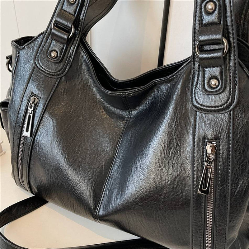 Detalhes da bolsa feminina hobo em couro preto com acabamento reforçado, costuras visíveis e zíper metálico.
