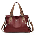 Bolsa Feminina de Mão Couro Genuíno vinho, alças marrom contrastantes. Design estruturado com couro texturizado e logo metálico. Elegante e versátil.
