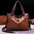 Bolsa feminina de couro envernizado marrom-caramelo com alças duplas e detalhes metálicos