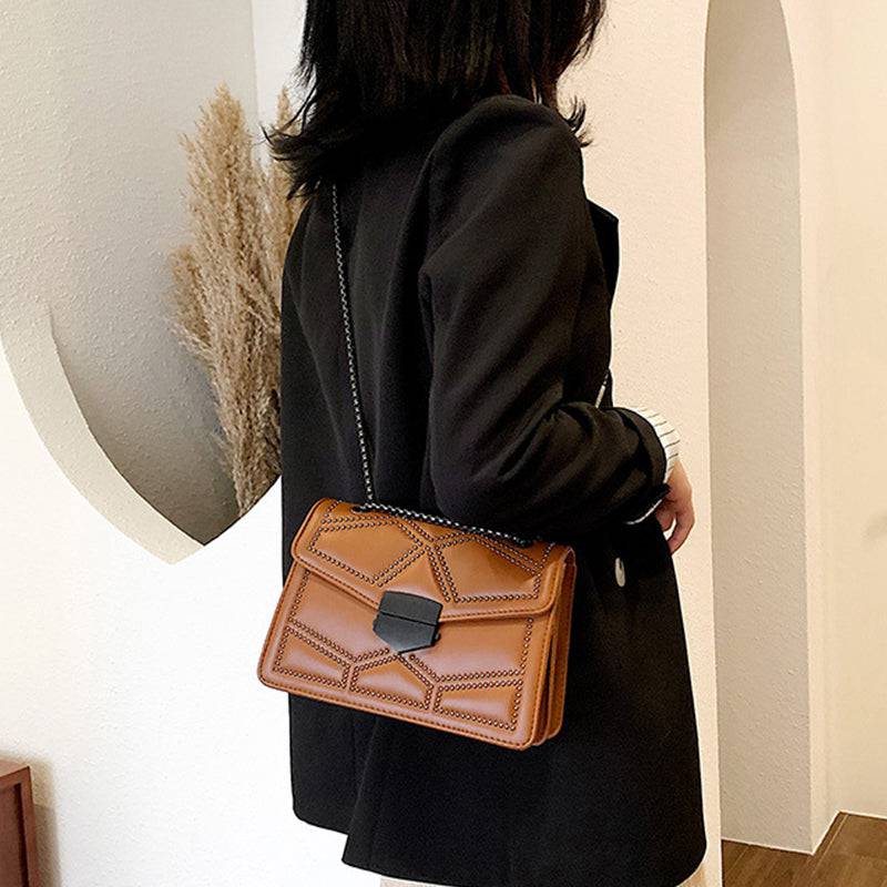 Bolsa Feminina Tiracolo Estruturada caramelo, design com rebites e alça de corrente. Estilo moderno e elegante.