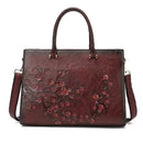 Bolsa tote de couro com relevo floral em tons quentes, alças de mão e alça transversal
