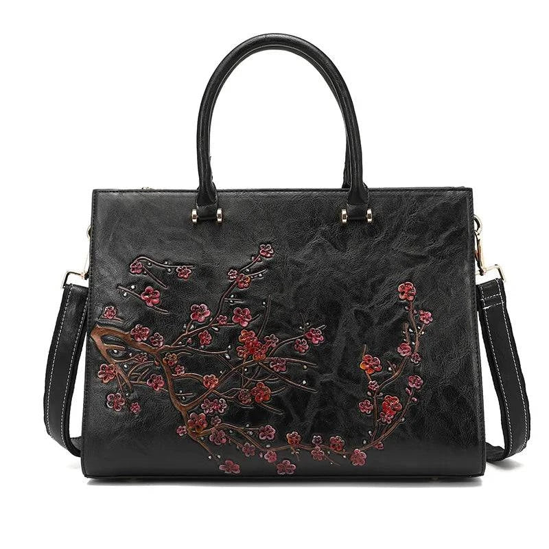 Bolsa Feminina Tote Couro Legítimo Imperix preta, com relevo floral em tons de rosa e marrom. Design estruturado, alças de mão e transversal. Estilo vintage e único.