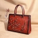Bolsa tote de couro vermelho-acastanhado com relevo floral no padrão