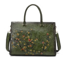 Bolsa tote de couro verde com bordado floral em tons dourados e vermelhos